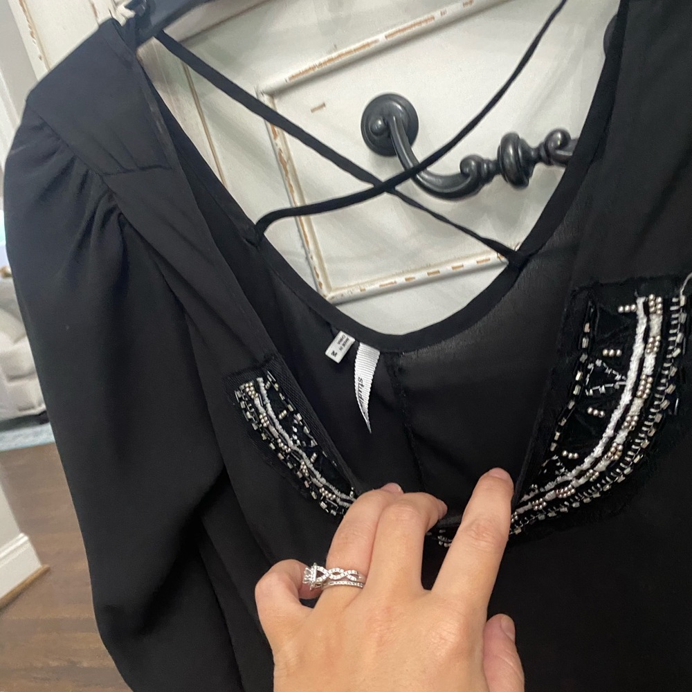 Black blouse with designs at the top. Size Medium.